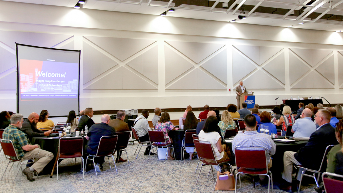 People sitting in a room listening to a speaker give a presentation.