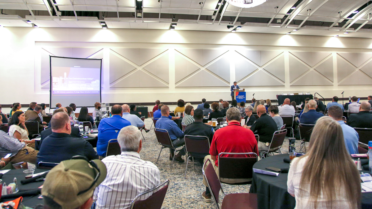 People sitting in a room listening to a speaker give a presentation.