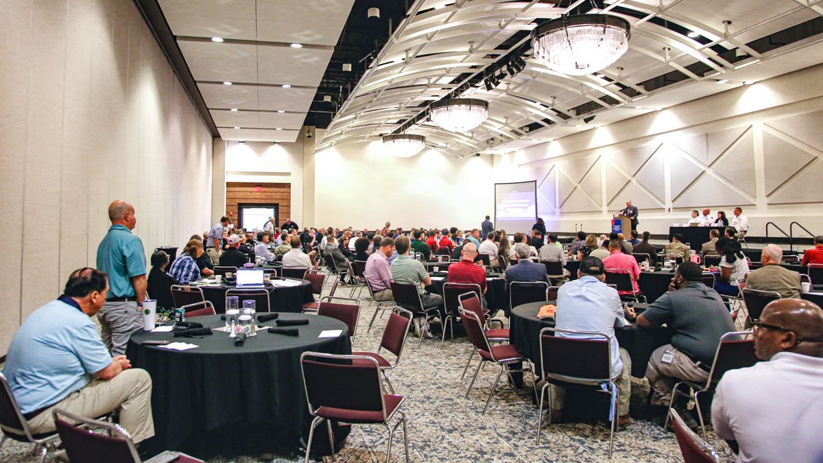 People sitting in a room listening to a speaker give a presentation.