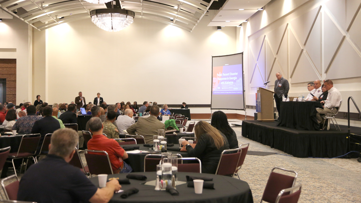People sitting in a room listening to a speaker give a presentation.